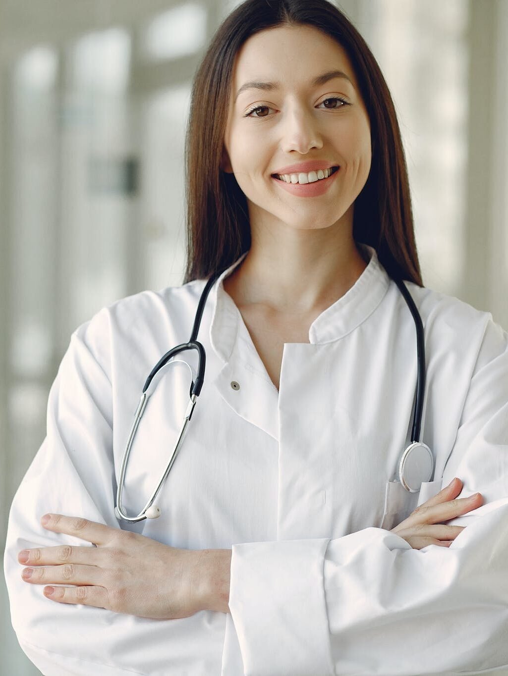 a nurse Crop in medical uniform with stethoscope standing in clinic corridor